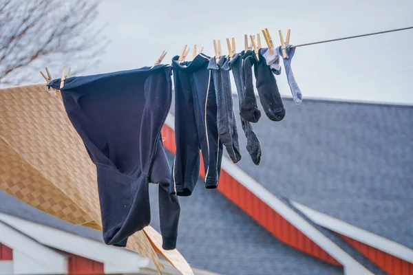 Buiten beeld van kleren van de Amish drogen in de zon en de lucht nadat Wasserij met een houten huis van rode achtergrond in Lancaster — Stockfoto