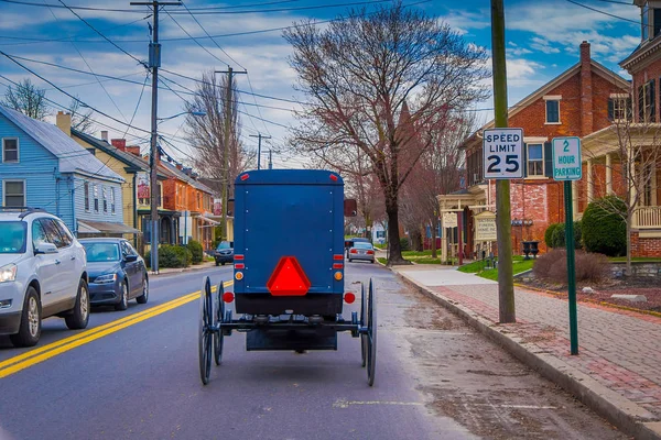 Lancaster, Amerikai Egyesült Államok - április, 18, 2018: Szabadtéri Nézd vissza a régi vágású Amish buggy, a lovaglás, a városi közúti körülvevő az autók és a jelek, a modern kor — Stock Fotó