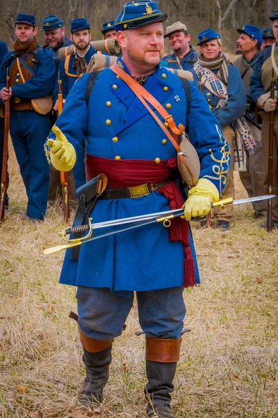 Moorpark, Usa - April, 18, 2018: Utomhus syn på människan bär blå uniform och håller ett svärd, som representerar den Civil War Reenactment i Moorpark, med deras soldater bakom — Stockfoto