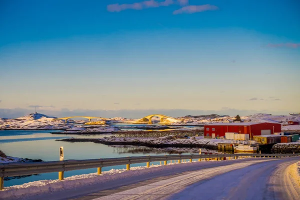 Strada ghiacciata a Skjelfjord con un ponte gimsoystraumen all'orizzonte nelle isole Lofoten — Foto Stock