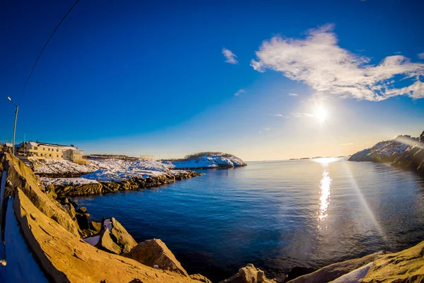 Vista ao ar livre de água limpa com um sol refletindo no lago na baía de Lofoten Islands — Fotografia de Stock