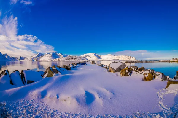 Venkovní vyhlídku s kameny, pokryté sněhem, v blízkosti jezera v Svolvaer — Stock fotografie
