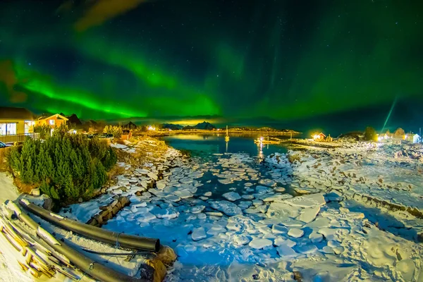 Incrível vista ao ar livre da aurora boreal verde no céu durante a noite e pequenos e médios pedaços de gelo deixados para trás durante uma maré baixa em um lago congelado — Fotografia de Stock