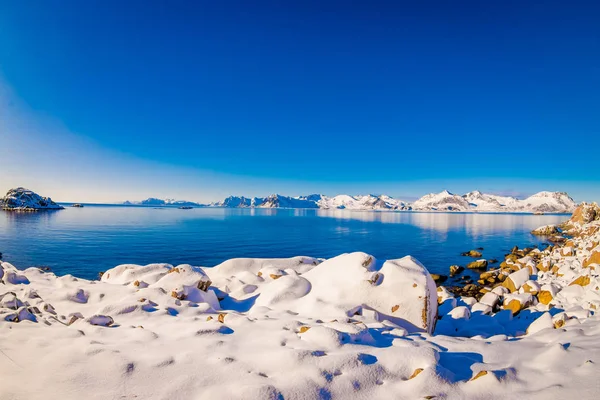 Hermosa vista al aire libre del lago y la orilla cubierta de nieve durante una fuerte tormenta de nieve en la temporada de invierno en el Círculo Polar Ártico — Foto de Stock