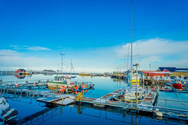 Henningsvaer, Noruega - 04 de abril de 2018: Vista ao ar livre do porto de pesca em Henningsvaer com edifícios típicos de madeira vermelha e pequenos barcos de pesca nas ilhas Lofoten — Fotografia de Stock