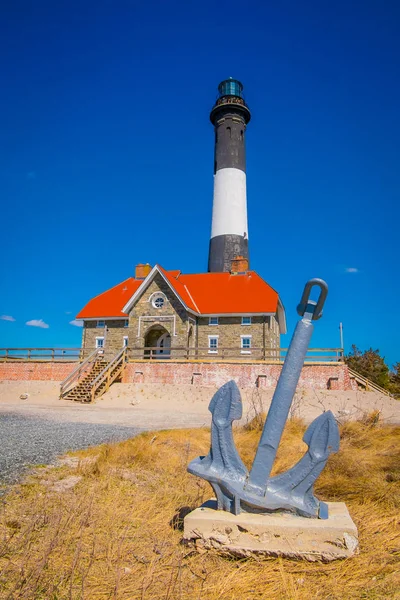长岛, 美国, 四月, 14, 2018: 蒙托克灯塔在长岛的最东部点与房子和锚在前面, 在东部汉普顿的镇在萨福克郡, 纽约 — 图库照片