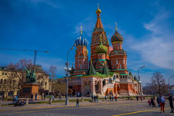 Moskau, russland - 24. April 2018: Außenansicht von Unbekannten, die in der Nähe der Basilikum-Kathedrale und des Spasskaya-Turms auf dem Roten Platz in einem herrlich blauen Himmel spazieren — Stockfoto