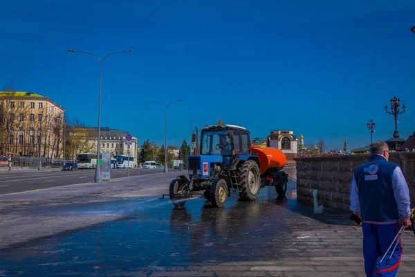 MOSCÚ, RUSIA - 24 DE ABRIL DE 2018: Vista al aire libre del hombre conduciendo una máquina de limpieza lavando el pavimento con agua después del evento en las calles de Moscú — Foto de Stock