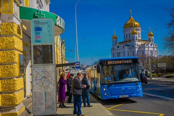 MOSCOW, RUSSIA- APRIL, 24, 2018: Outdoor view of unidentified people boarding a bus with Russian Orthodox Cathedral, the Temple Of Christ The Savior behind — Stock Photo, Image