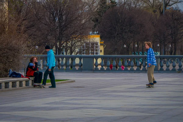 MOSCOW, RÚSSIA- ABRIL, 24, 2018: Vista ao ar livre de adolescentes praticando patinação em um parque sem proteção, em um parque Gorky durante um dia ensolarado — Fotografia de Stock