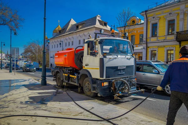 Moskva, Rusko - 24 duben 2018: názor člověka řídit zametací stroj mytí dlažby s vodou po události na ulicích, v nádherné modré obloze ve městě Moskva — Stock fotografie