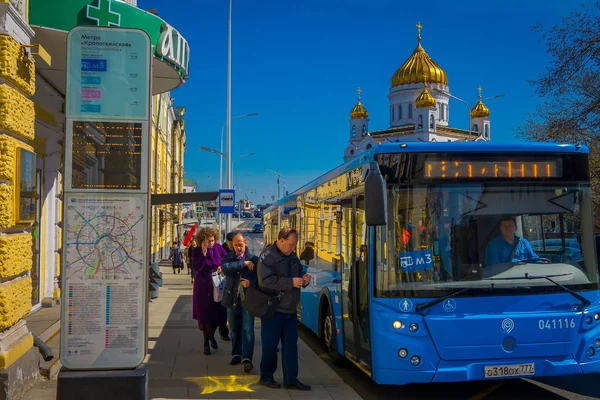 MOSCOW, RÚSSIA- 24 de abril de 2018: Vista ao ar livre de pessoas não identificadas embarcando em um ônibus com a Catedral Ortodoxa Russa, o Templo de Cristo Salvador por trás — Fotografia de Stock