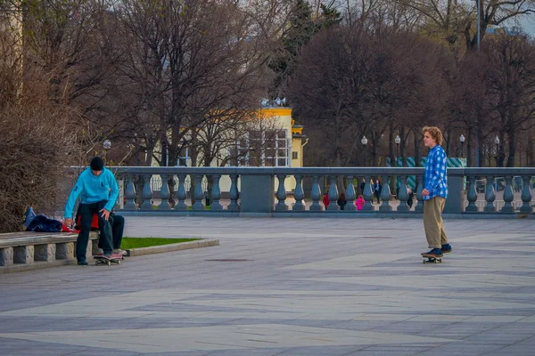 MOSCOW, RÚSSIA- ABRIL, 24, 2018: Vista ao ar livre de adolescentes praticando patinação em um parque sem proteção, em um parque Gorky durante um dia ensolarado — Fotografia de Stock