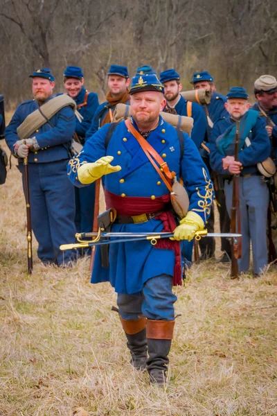 MOORPARK, EE.UU. - 18 DE ABRIL DE 2018: Vista al aire libre del hombre con uniforme azul y sosteniendo una espada, representando la Representación de la Guerra Civil en Moorpark, con sus soldados detrás — Foto de Stock