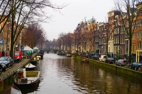 Amsterdam, Niederlande, 23. April 2018: Blick auf einige Autos in der Straße in der Nähe von vielen Booten in den Kanälen von amsterdam geparkt, ist die Hauptstadt und bevölkerungsreichste Stadt der Niederlande — Stockfoto