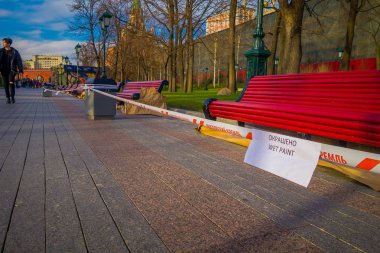 Moskova, Rusya - Nisan, 24, 2018: açık kırmızı metalik sandalye sadece Zaryadye Park'ta boyalı yakın yürüyen kimliği belirsiz adam Moskova Kremlin yeni bir kentsel Parkı görülmektedir