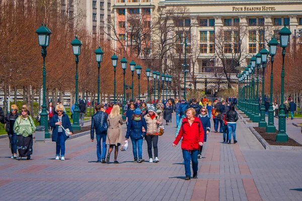 MOSCÚ, RUSIA - 24 DE ABRIL DE 2018: Vista al aire libre de personas no identificadas caminando por las calles con lámparas públicas verdes a cada lado, ubicadas en un parque en Moscú —  Fotos de Stock