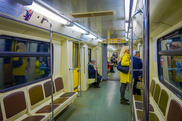 Moskva, Rusko - 29 dubna 2018: lidé uvnitř metra, perspektivní pohled na moderní prostorný interiér a pohodlná sedadla moderní vlak pohybující se rychle uvnitř městského tunelu metra — Stock fotografie