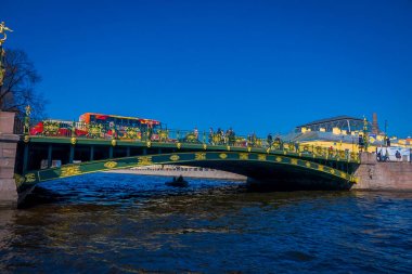 St Petersburg, Rusya, 02 Mayıs 2018: açık mavi gökyüzü ile güzel bir güneşli gün St. Petersburg Moika Nehri boyunca yeşil köprü altında bir yat geçerken insanlarda görünümünü