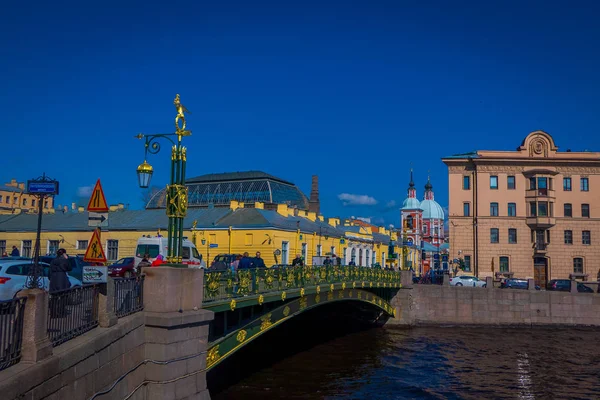 ST. PETERSBURG, RÚSSIA, 02 MAIO 2018: Vista ao ar livre de pessoas não identificadas andando sobre uma ponte verde ao longo do rio Moyka, em São Petersburgo, em um lindo dia ensolarado — Fotografia de Stock