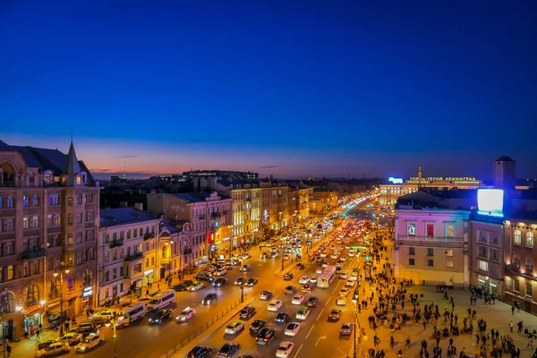 ST. PETERSBURG, RUSSIA, 01 MAY 2018: Above view of traffic in the streets and crowd of people walking in the Nevsky Avenue of the city with a gorgeous sunset view in the horizont — Stock Photo, Image