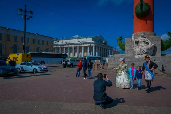 ST. PETERSBURG, RUSSIE, 01 MAI 2018 : Papa prenant des photos à ses enfants devant des colonnes rostrales dans le centre-ville historique de Saint-Pétersbourg, monument touristique populaire, patrimoine mondial de l'UNESCO — Photo