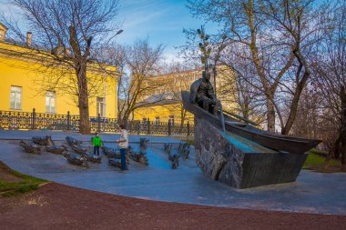 MOSCOW, RUSSIA- APRIL, 29, 2018: Unidentified man with his boy playing close to the Monument to writer Mikhail Sholokhov on Gogol Boulevard in Moscow clipart