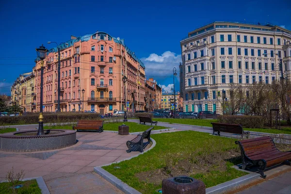 サンクトペテルブルク、ロシア、2018 年 5 月 1 日: サンクトペテルブルクに位置する中心の後ろに巨大な建物が付いている公園の od 公共の椅子を見る — ストック写真