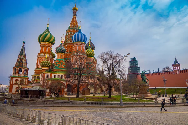 Moskau, russland - 29. April 2018: Unbekannte spazieren bei bewölktem Himmel über den Roten Platz, den Kreml und die Basilikum-Kathedrale, Kreml ist eine der wichtigsten Touristenattraktionen in Moskau — Stockfoto