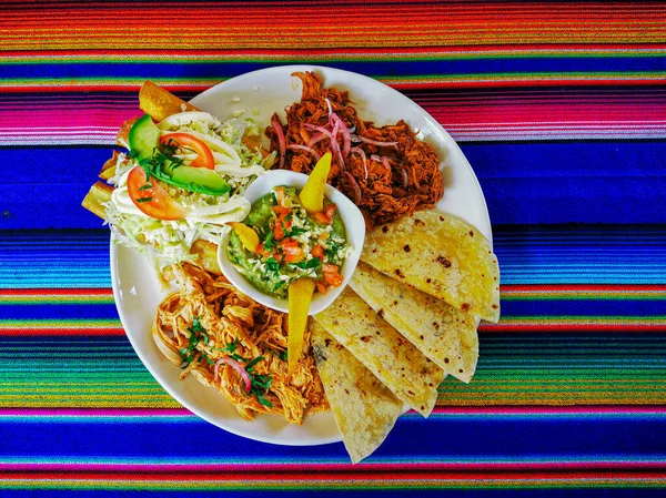 Mexican food mix colorful background, guacamole, cochinita pibil, flautas and quesadilla. — Stock Photo, Image