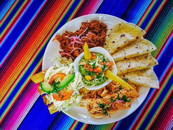 Mexican food mix colorful background, guacamole, cochinita pibil, flautas and quesadilla. — Stock Photo, Image