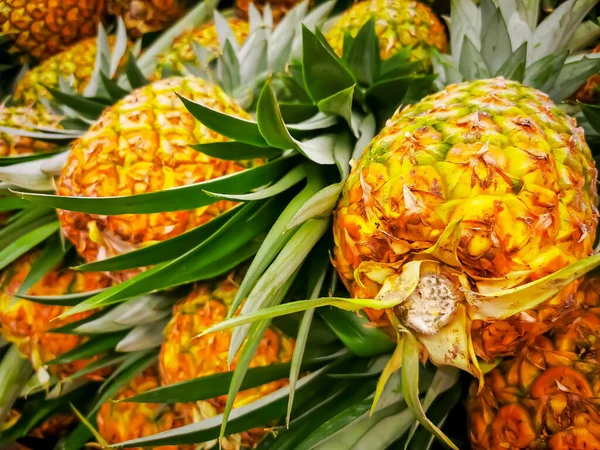 Pile pineapple fruit which has been harvested and display for sale on farmers table in market — Stock Photo, Image