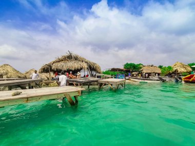 Cholon sahilindeki okyanus barı. Kolombiya 'daki Baru-Cartagena sahilindeki turkuaz mavi denizde tropikal kulübe koltukları.