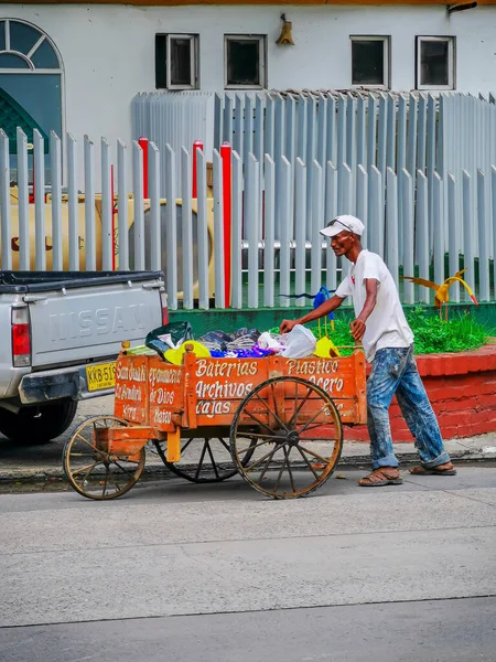 CARTAGENA, KOLUMBIEN - 12. NOVEMBER 2019: Straßenhändler mit Einkaufswagen und Obst im bunten historischen Stadtzentrum. — Stockfoto