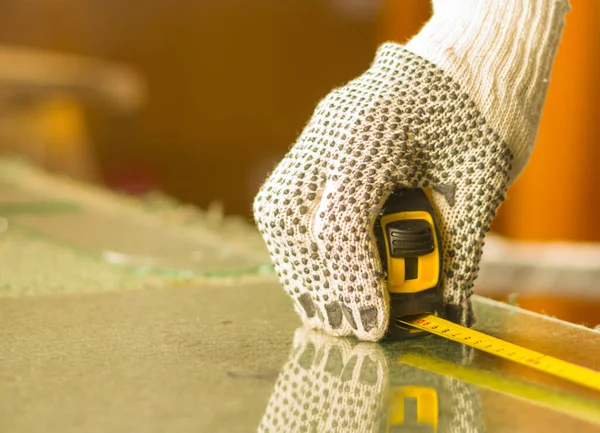 Closeup hand wearing white work gloves using measure tool on transparent piece of glass — Stock Photo, Image