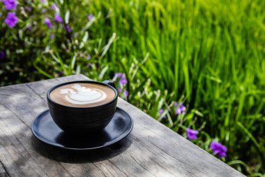 Cappuccino bir fincan pirinç çeltik, Umalas, Bali Adası, Endonezya'nın kenarındaki bir açık alan kafede masada