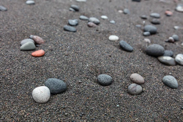 Pebbles na praia de areia preta em Padangbai, Bali Island, Indonésia — Fotografia de Stock