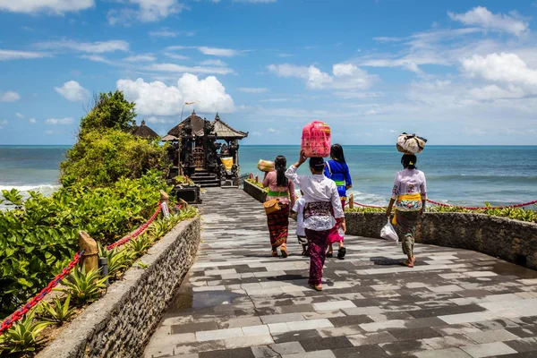 Balinesische Frauen tragen Körbe mit Opfergaben zu einem Tempel in Pura Tanah, Bali Island, Indonesien — Stockfoto