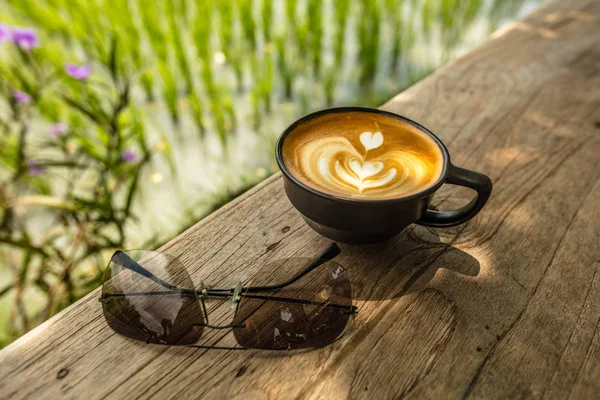 Fincan Cappuccino ve güneş gözlüğü çeltik, Bali Adası, Endonezya kenarındaki masada — Stok fotoğraf