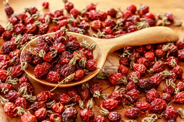 Rose hips bir ahşap tepsi ve bir tahta kaşık kuru. Üstten Görünüm.  