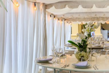 Set tablo bir beyaz düğün yemeği için orkide ile dekore edilmiştir.. 