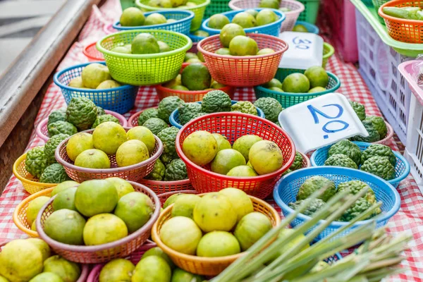 Fruit and vegetables in plastic baskets at famous Maeklong railway market, Samut Songkhram province, Thailand
