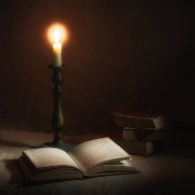 mum ışığında ahşap bir masa üzerine eski kitap