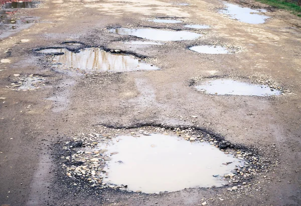 Yol kıştan sonra yok. Yoldaki çukurlara su birikintileri.