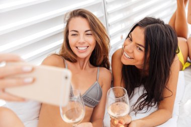 İki mutlu kızlar selfie holding gözlük içecekler yapma gülümseyen