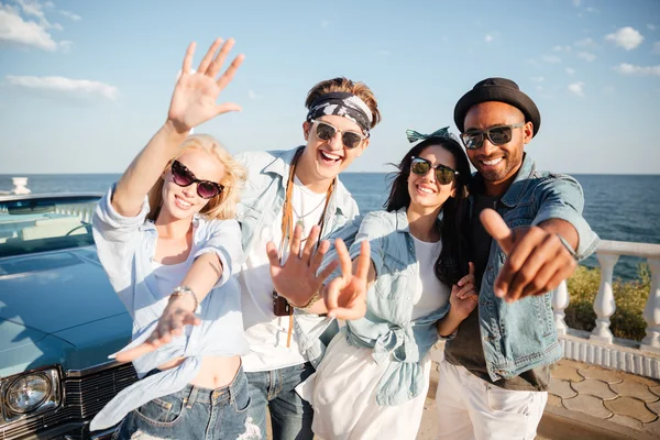 Багатоетнічна група веселих молодих людей, що стоять на набережній — стокове фото