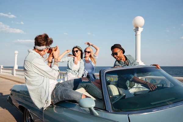 Hermosos jóvenes conduciendo cabriolet y hablando fotos en verano —  Fotos de Stock