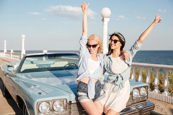 Deux femmes debout les mains levées près du cabriolet vintage — Photo