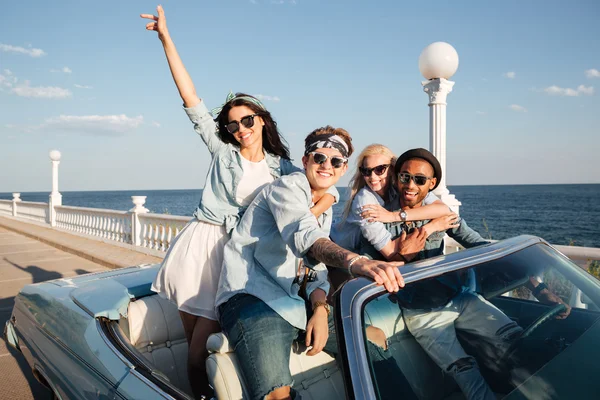 Cheerful young friends driving car outdoors — Stock Photo, Image