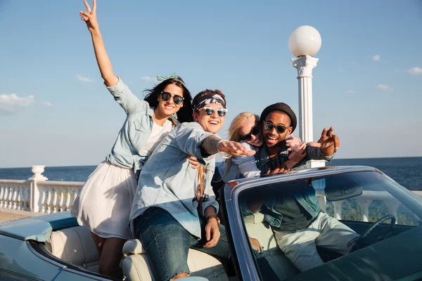 Jeunes gens heureux conduisant voiture près de la mer — Photo